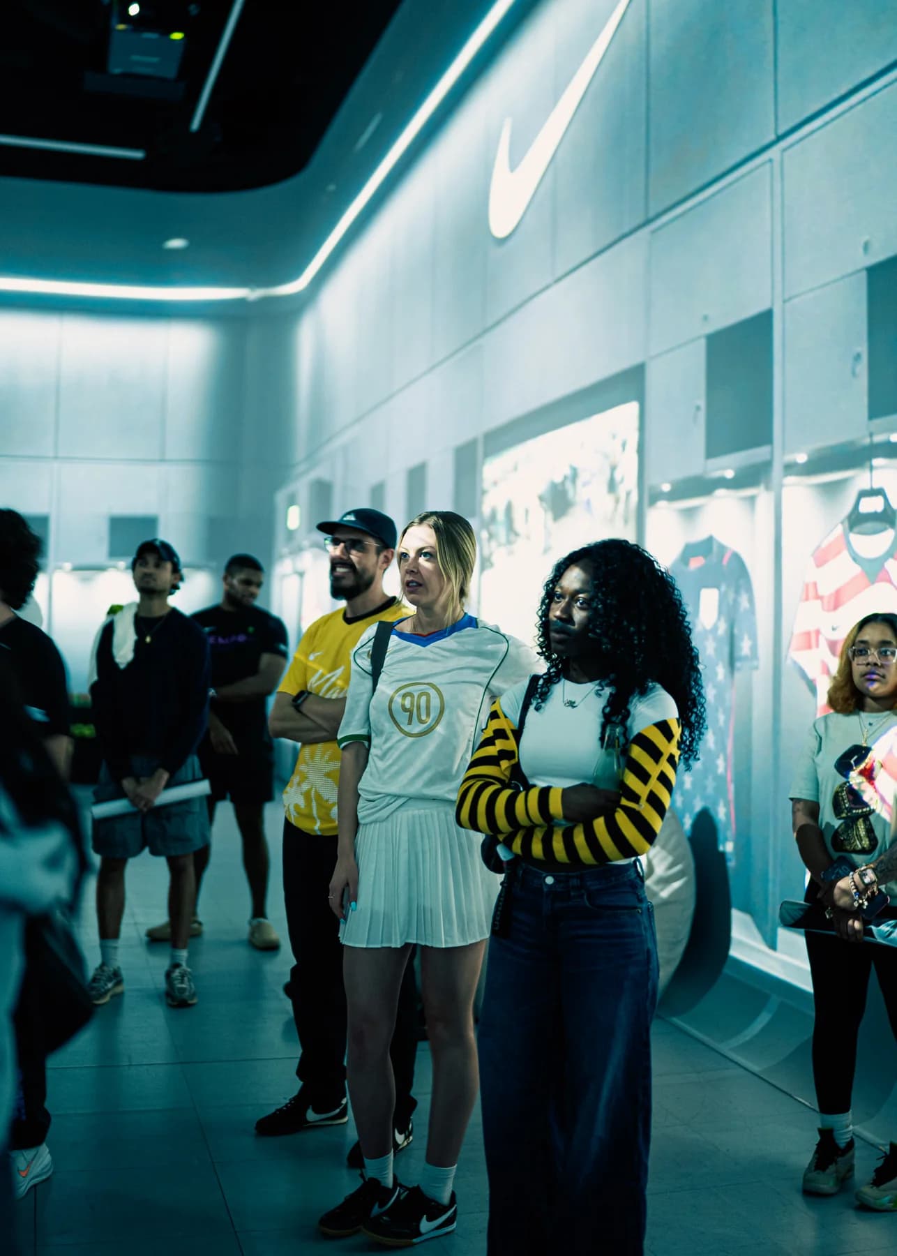 Visitors exploring the illuminated Nike Football displays